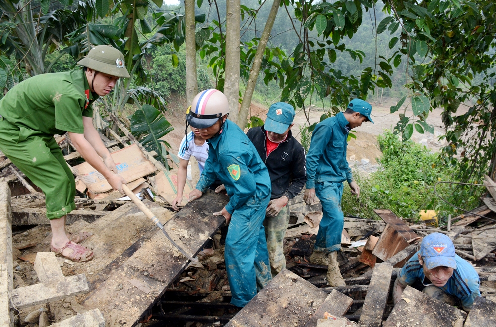-Công an, dân quân huyện Nam Trà My giúp dân khắc phục hậu quả cơn bão số 9